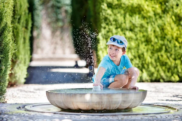 Boy having fun with fountain shot during summer time — Stock Photo, Image