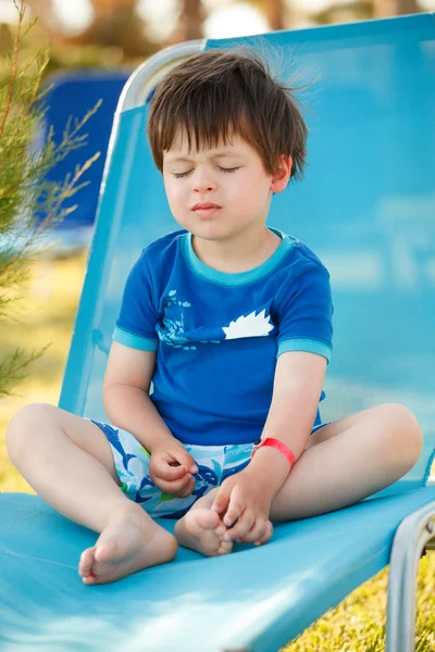 Ładny toddler chłopiec siedzi na solarium — Zdjęcie stockowe