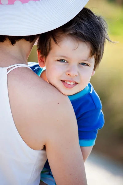 Porträt eines süßen Jungen auf den Händen der Mutter — Stockfoto