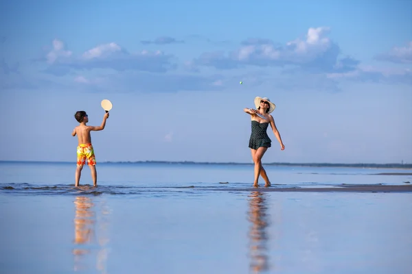 Junge Mutter und Sohn spielen am Strand — Stockfoto