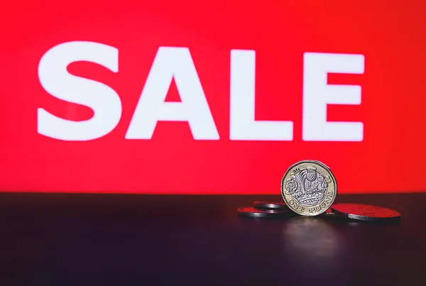 一个英镑硬币和Sale字 英国货币 英镑硬币形象 销售概念 季节性销售 黑色星期五 国际年的销售 图库图片