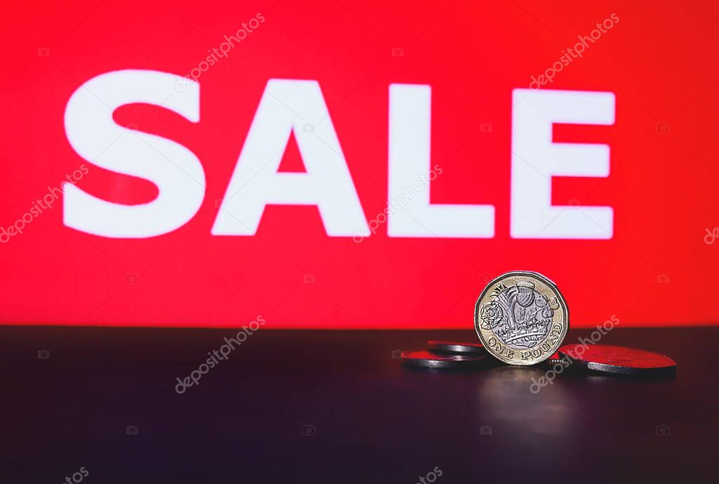 One Pound Coin and SALE word. British money. Pound coins image. Sale concept. Seasonal sale, Black Friday. Sale of the Year.