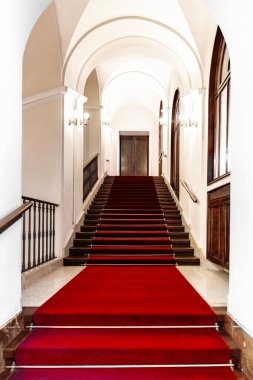 PRAG, CZECH Cumhuriyet - 1 Nisan 2022: Eski Belediye Binası içi. Merdivenleri, kırmızı halısı ve kemerleri olan uzun koridor ya da lobi odası.