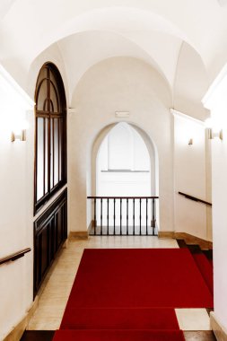 PRAG, CZECH Cumhuriyet - 1 Nisan 2022: Eski Belediye Binası içi. Merdivenleri, penceresi, kırmızı halısı ve kemerleri olan uzun koridor ya da lobi odası.