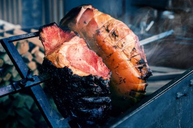 Bir şişte açık ateşte kızartılmış iki büyük parça yakın çekim. Lezzetli, lezzetli domuz kebabı açık havada ızgarada kızartılıyor.