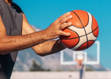 Yaşlı adamın elleri güneşli yaz gününde spor topunu geçmeye hazır..