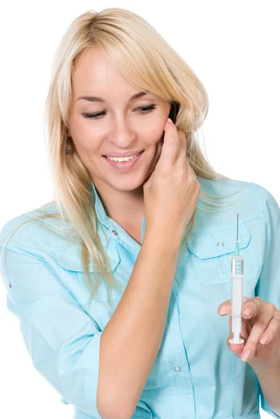 The young doctor holds a syringe and speaks by phone — Stock Photo, Image