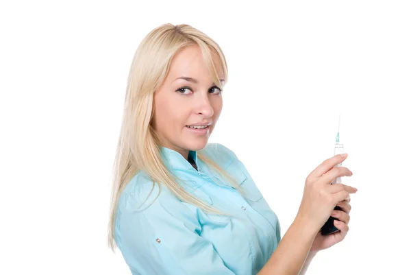 Médica jovem com uma seringa e telefone celular em uma mão — Fotografia de Stock