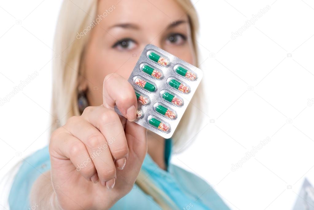 Young nurse holding pack of pills.