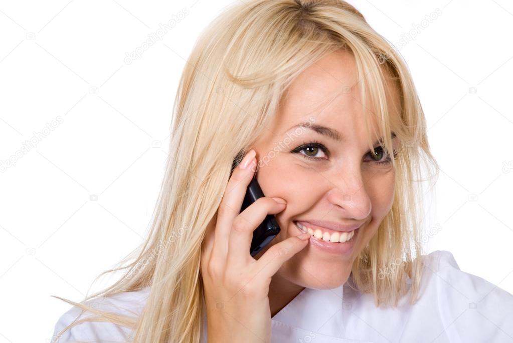 Young smiling beautiful doctor talks by mobile phone