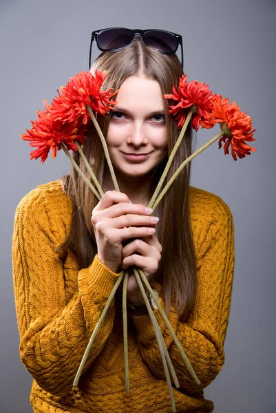 Vacker kvinna med färska hälsa hud i ansikte och röd blomma — Stock fotografie