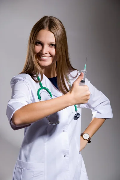 Pielęgniarka z strzykawki pokazuje kciuk — Zdjęcie stockowe