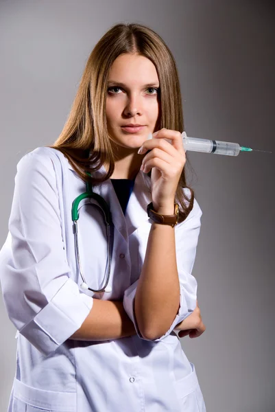 Женщина-врач с большим шприцем — стоковое фото