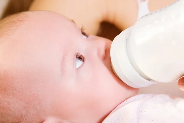 Um bebê comendo leite de mamadeira — Fotografia de Stock
