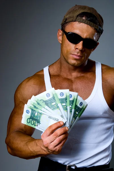 Handsome muscular man with euro banknotes in hand. — Stock Photo, Image