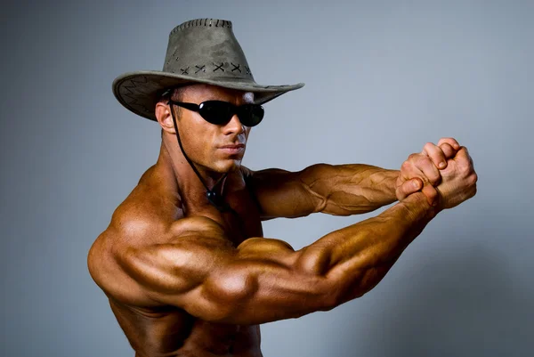 Muscular male in a hat and sunglasses — Stock Photo, Image