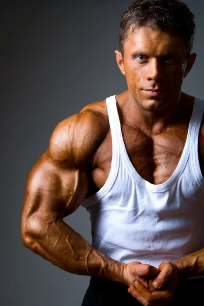 Ein Mann zeigt im Studio seine Muskeln — Stockfoto