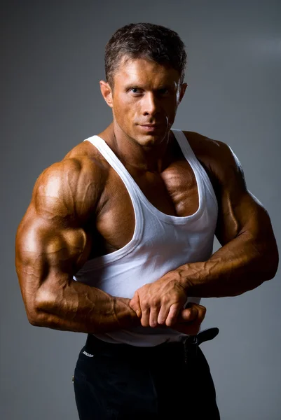 Un homme montre ses muscles en studio — Photo