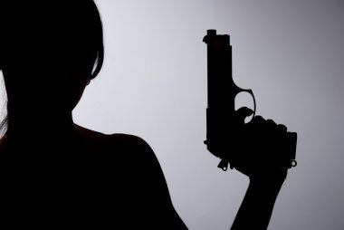 gri bir arka plan üzerinde silahlı bir kadın silueti
