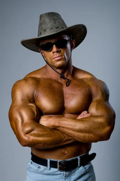 Muscular male in a hat and sunglasses — Stock Photo, Image