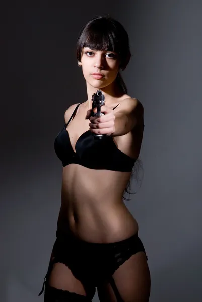 Mulher na moda elegante com uma pistola nas mãos — Fotografia de Stock