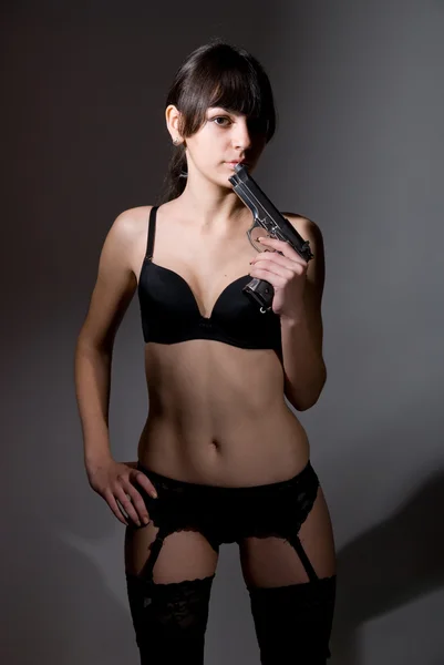 Sexy chica sosteniendo un arma negra . —  Fotos de Stock