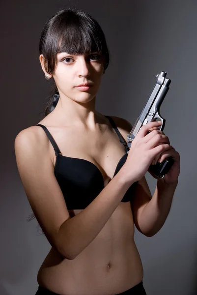 Menina sexy segurando uma arma preta . — Fotografia de Stock