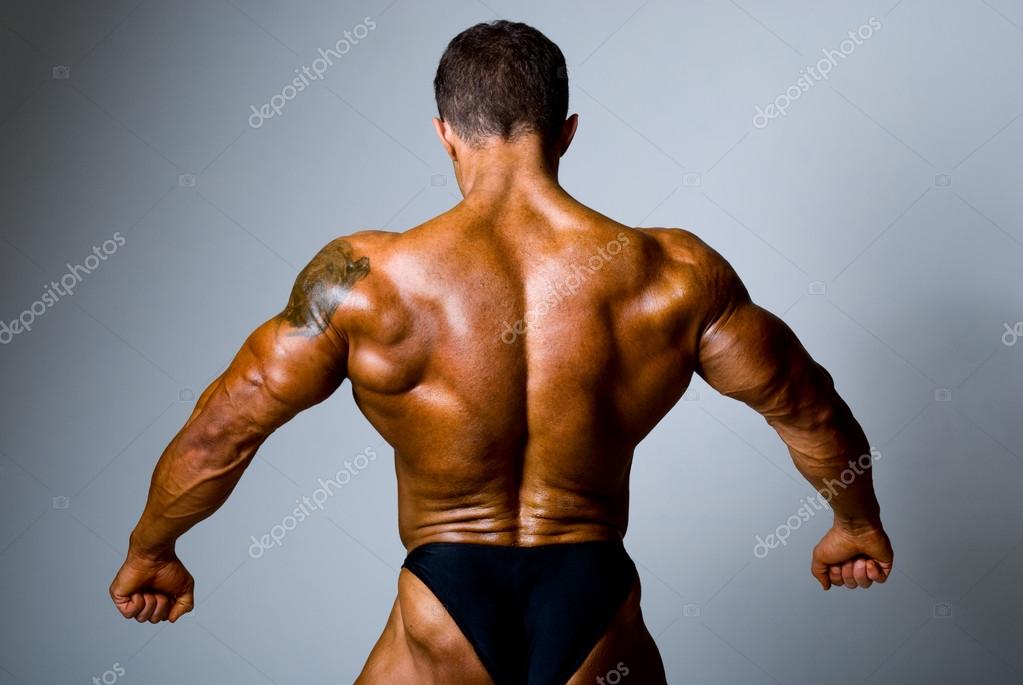 O homem musculoso nas costas com uma tatuagem no ombro — Foto © kanzefar #18295401