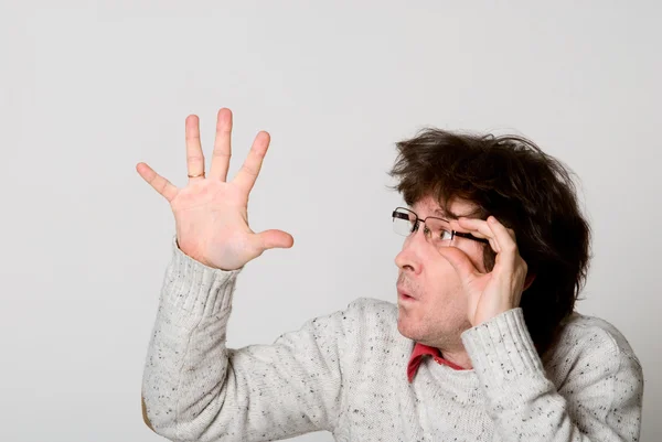 Homem com cabelo desgrenhado apontando a mão para algo interessante — Fotografia de Stock