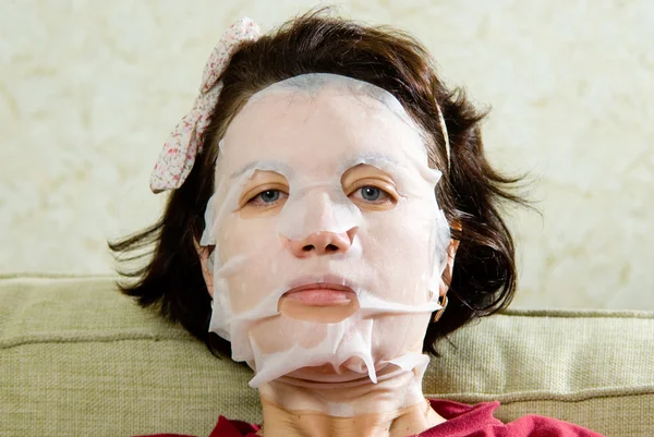 Stående kvinna tillämpa föryngrande ansiktsmask i ansiktet — Stockfoto