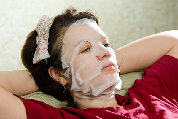 Stående kvinna tillämpa föryngrande ansiktsmask i ansiktet — Stockfoto