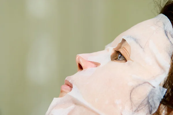 Portrait in Profile woman applying rejuvenating facial mask on h — Stock Photo, Image