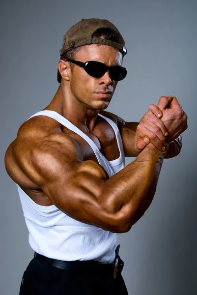 Schöner muskulöser Mann mit Sonnenbrille, der seinen Bizeps zeigt — Stockfoto