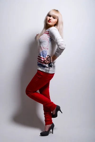 Loira jovem sexy em um jeans vermelho — Fotografia de Stock