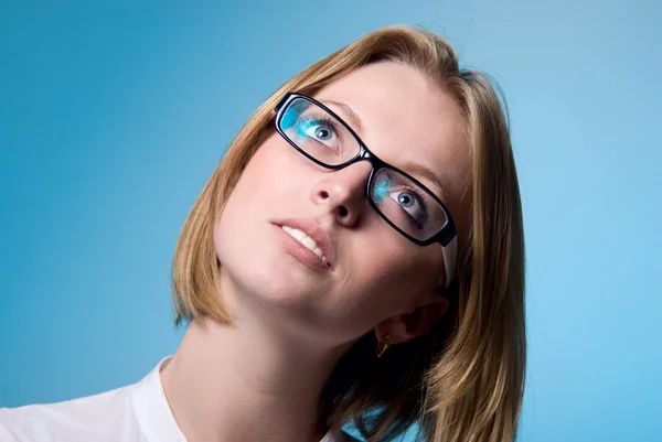 Retrato de cerca de una chica con gafas. La chica mira hacia arriba . — Foto de Stock