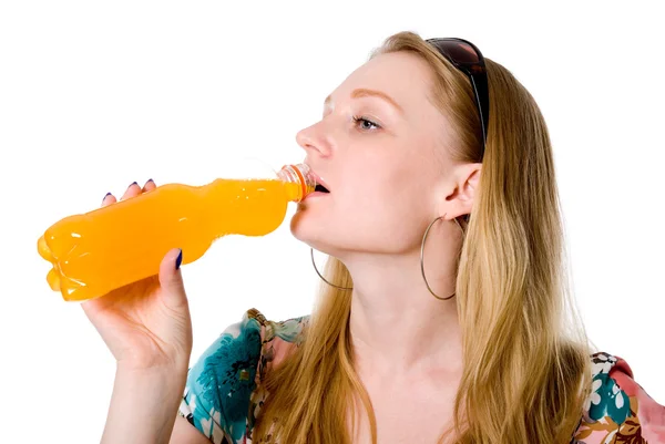 Portrait of a beautiful girl drinking from a bottle orange juice — Stock Photo, Image