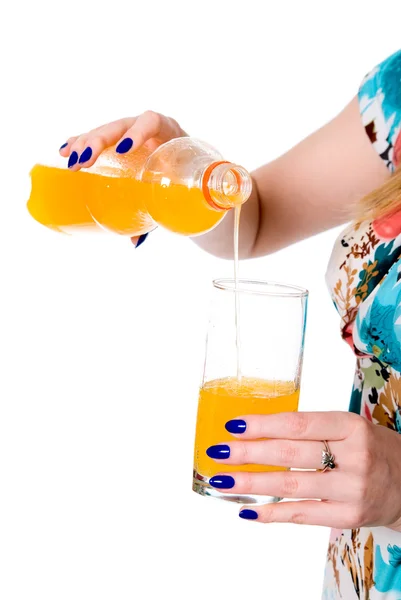 Mulher derramando suco de laranja de uma garrafa em um copo — Fotografia de Stock