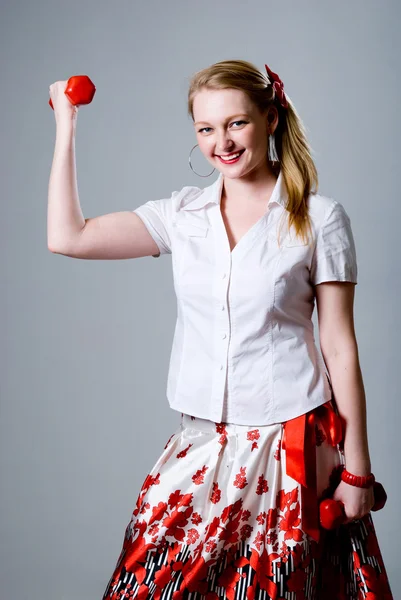 Merry successful businesswoman trains with dumbbells — Stock Photo, Image