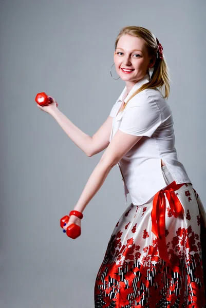 Merry successful businesswoman trains with dumbbells. On a gray — Stock Photo, Image