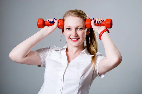 Başarılı bir iş kadını ile bir dumbbell tapınaklar — Stok fotoğraf