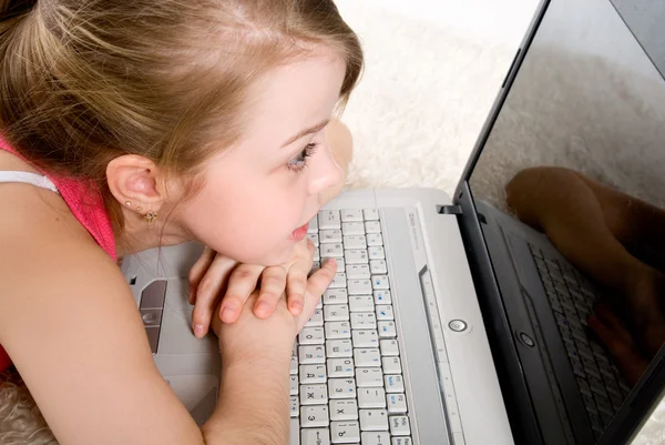 Μια νεαρή γυναίκα που βρίσκεται στο πάτωμα μπροστά από το laptop — Φωτογραφία Αρχείου