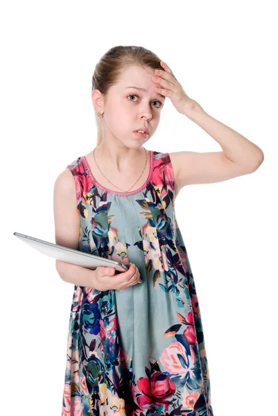 Задумчивая девушка в цветущем платье с планшетным ПК — стоковое фото