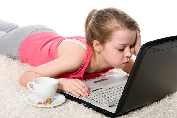 Chica cansada con un ordenador portátil y una taza de café —  Fotos de Stock