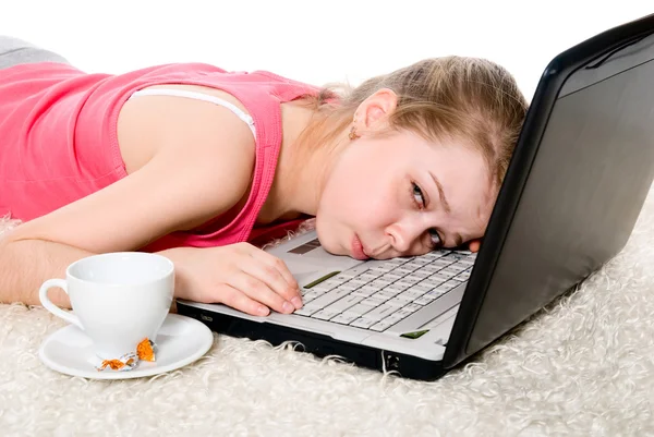Chica cansada con un ordenador portátil y una taza de café —  Fotos de Stock