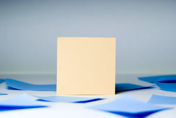 Yellow blank sheet for records amid blue sheets lying — Stock Photo, Image