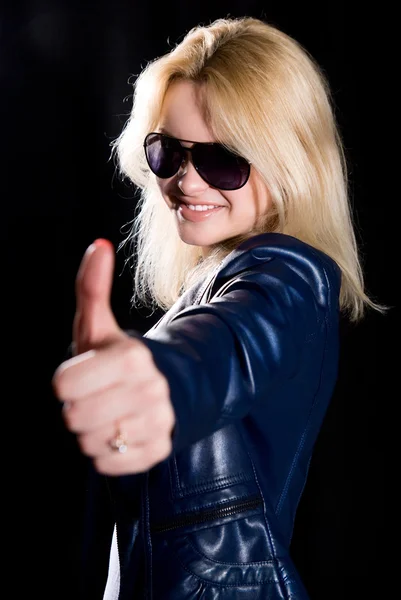 Young modern girl with thumb up against a black background — Stock Photo, Image