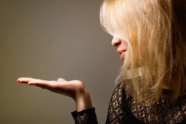 Portrait of a cute young female blowing a kiss towards copyspace — Stock Photo, Image