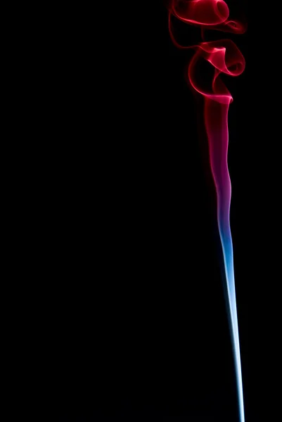 Um toque de fumaça azul e vermelha em um fundo preto — Fotografia de Stock