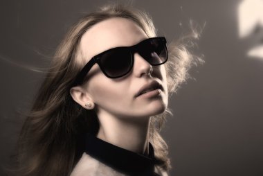 Kara gözlüklü genç bir kızın yakın çekim portre.