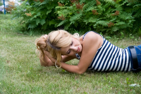 Pensive mulher deitada na grama . — Fotografia de Stock